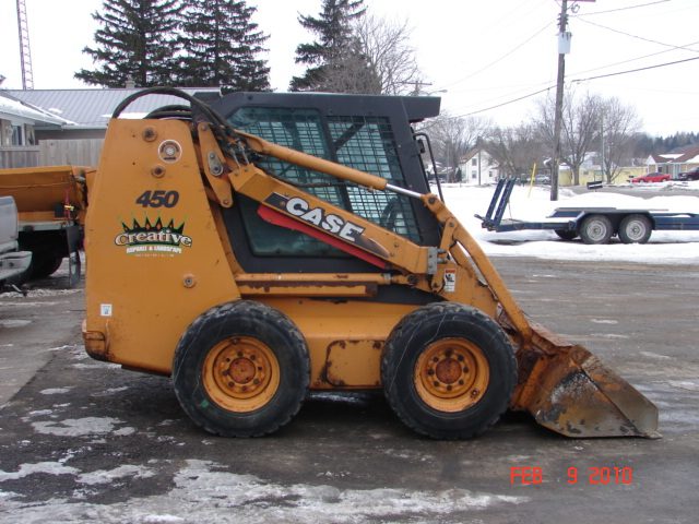 A yellow and black tractor parked in the snow