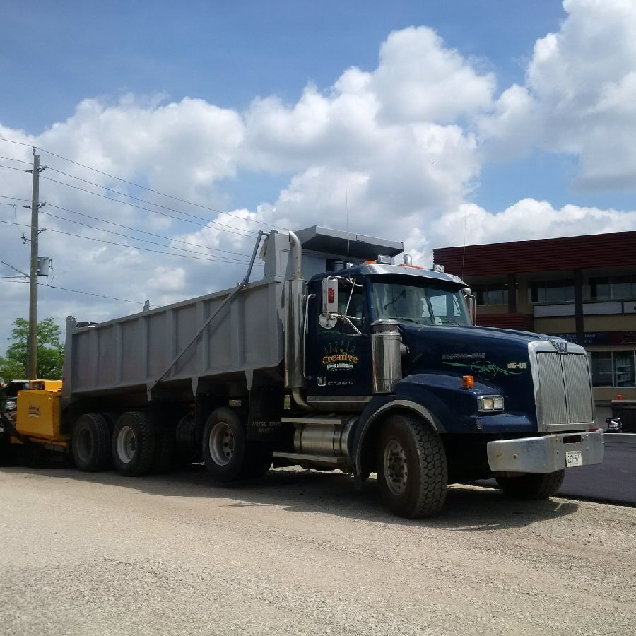 A dump truck is parked on the side of the road.