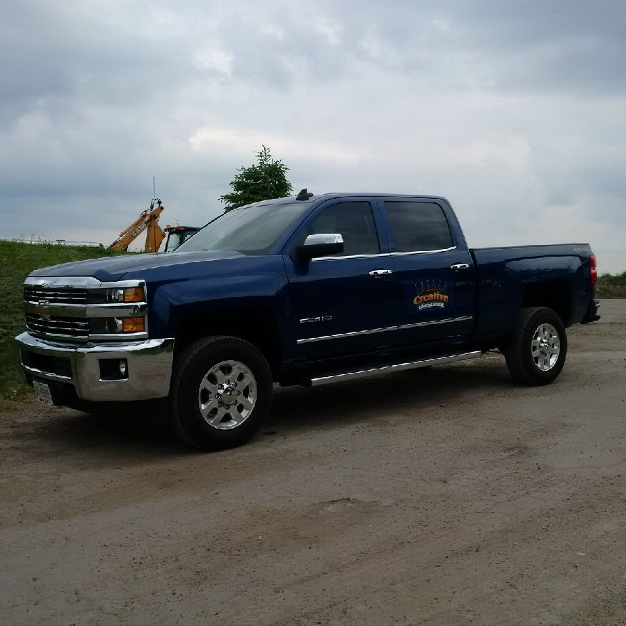 A blue truck parked on the side of a road.