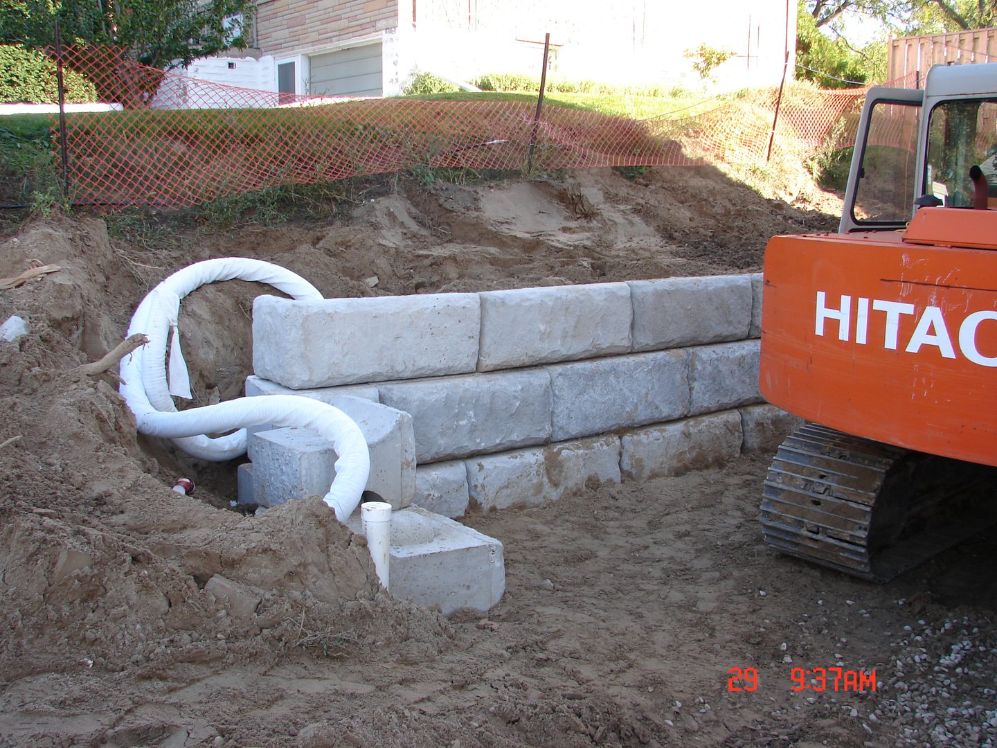 A construction site with a brick wall and pipes.